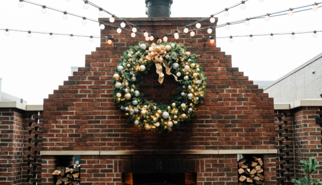 christmas wreath above outdoor fireplace