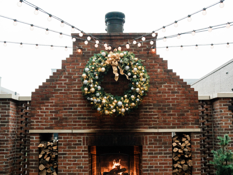 christmas wreath above outdoor fireplace