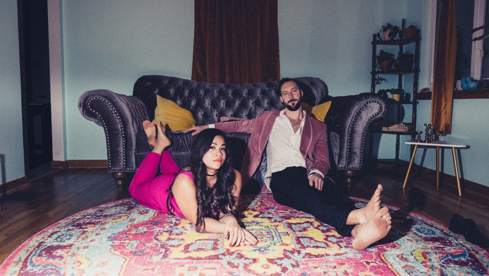 bloom deluxe cover art with man and woman hanging out on the floor in front of a couch