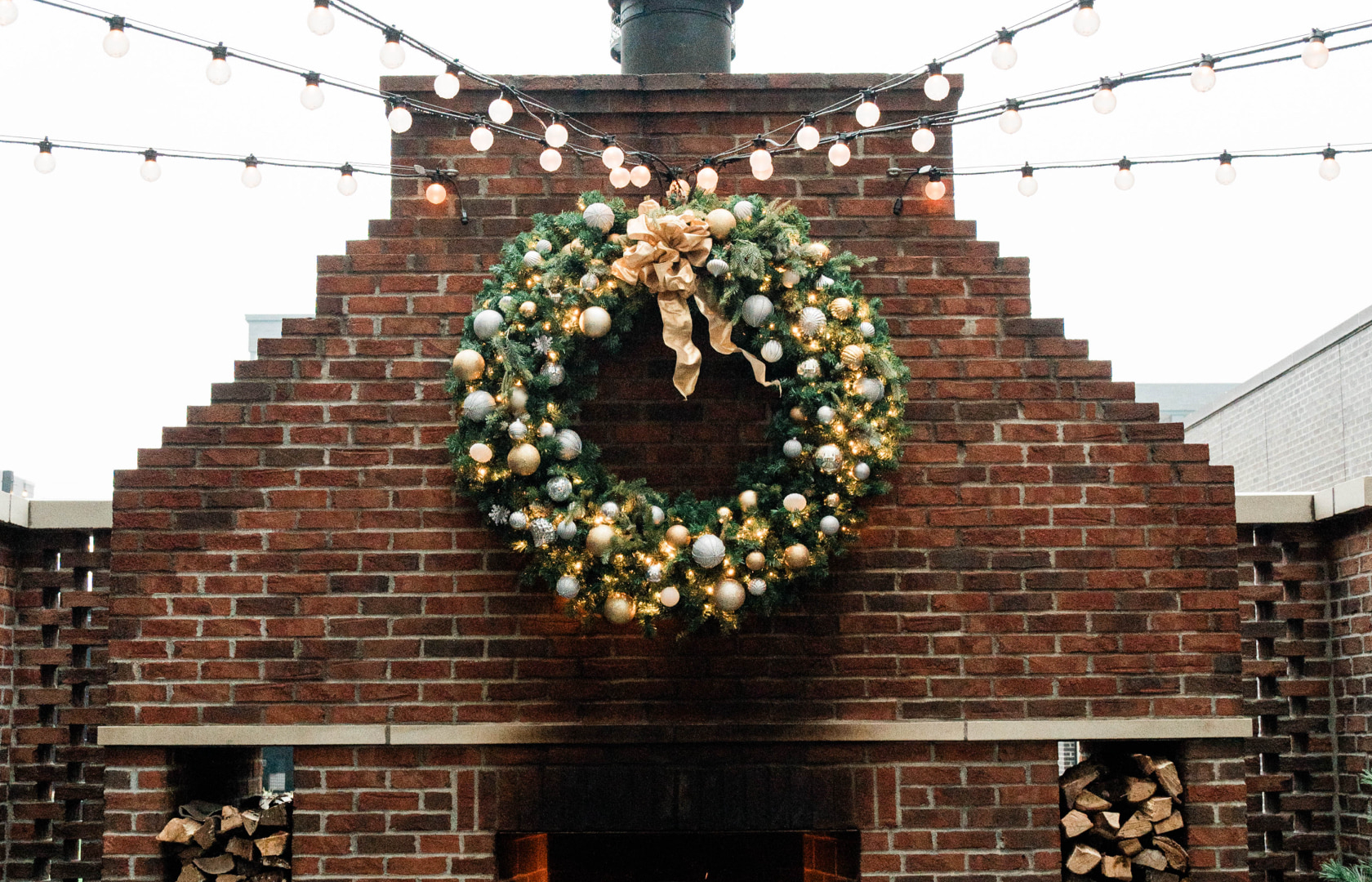 christmas wreath above outdoor fireplace