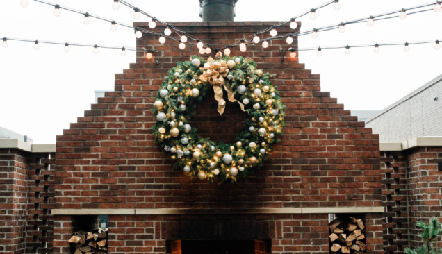 christmas wreath above outdoor fireplace