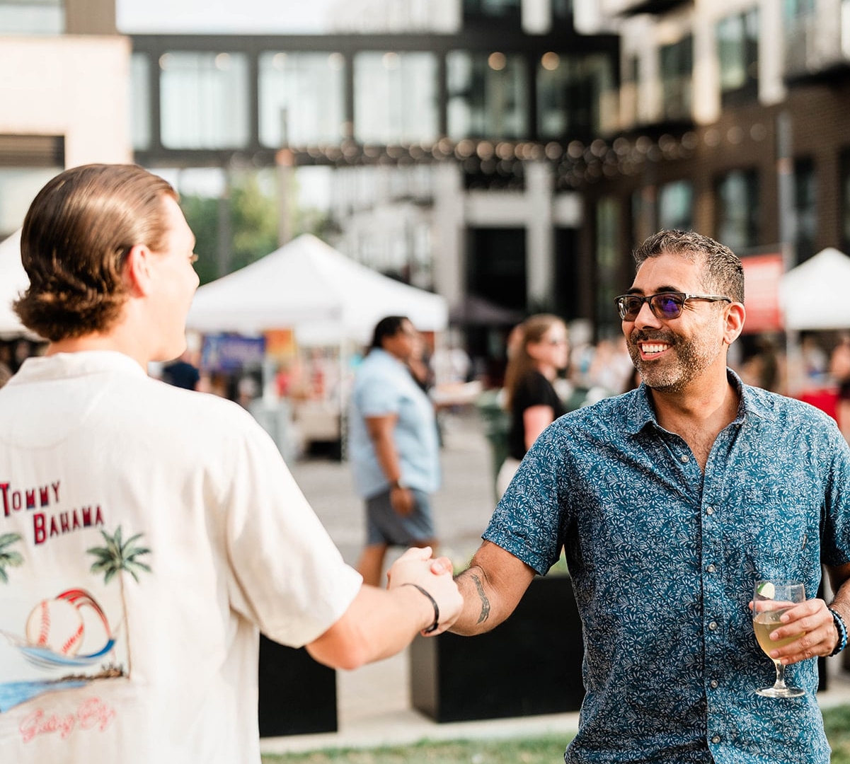Two men shaking hands at the lawn at high water alley