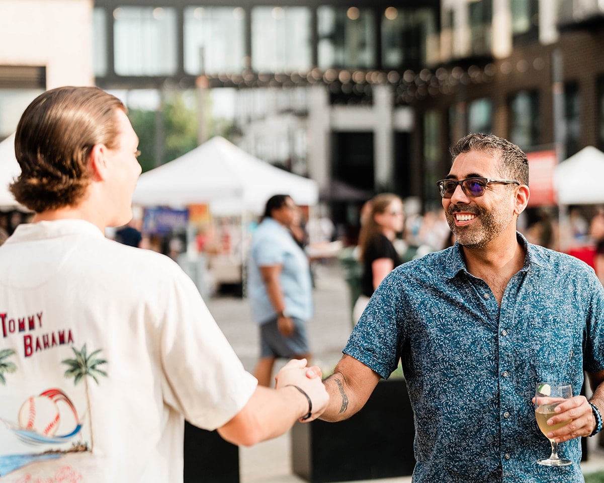 Two men shaking hands at the lawn at high water alley