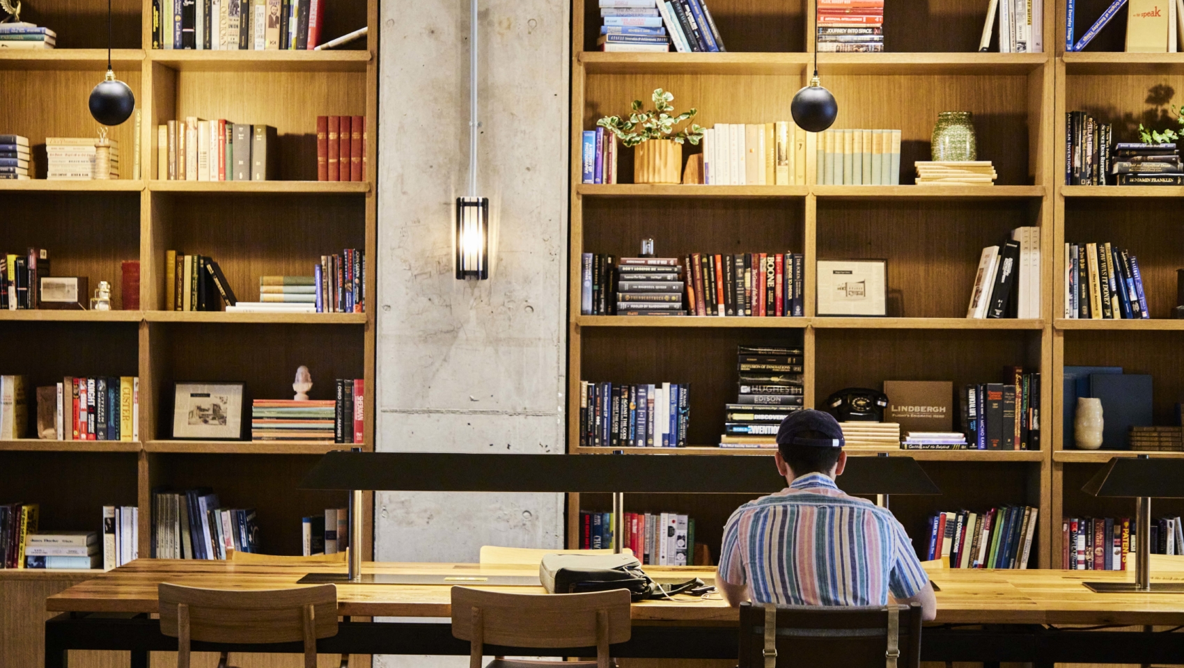 Student sitting in front of library bookshelf