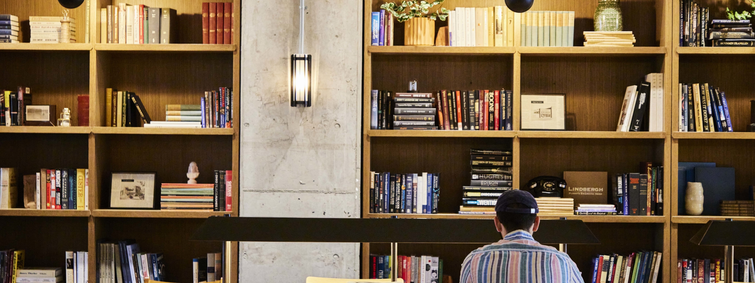 Student sitting in front of library bookshelf