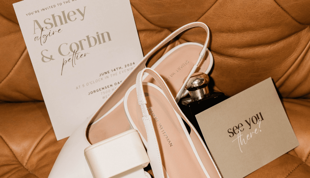 Setup of wedding shoe, invite and accessories on a couch