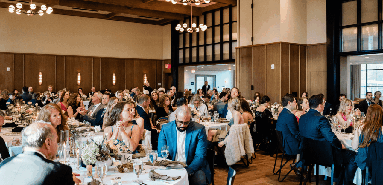 Ballroom filled with people sitting down at wedding