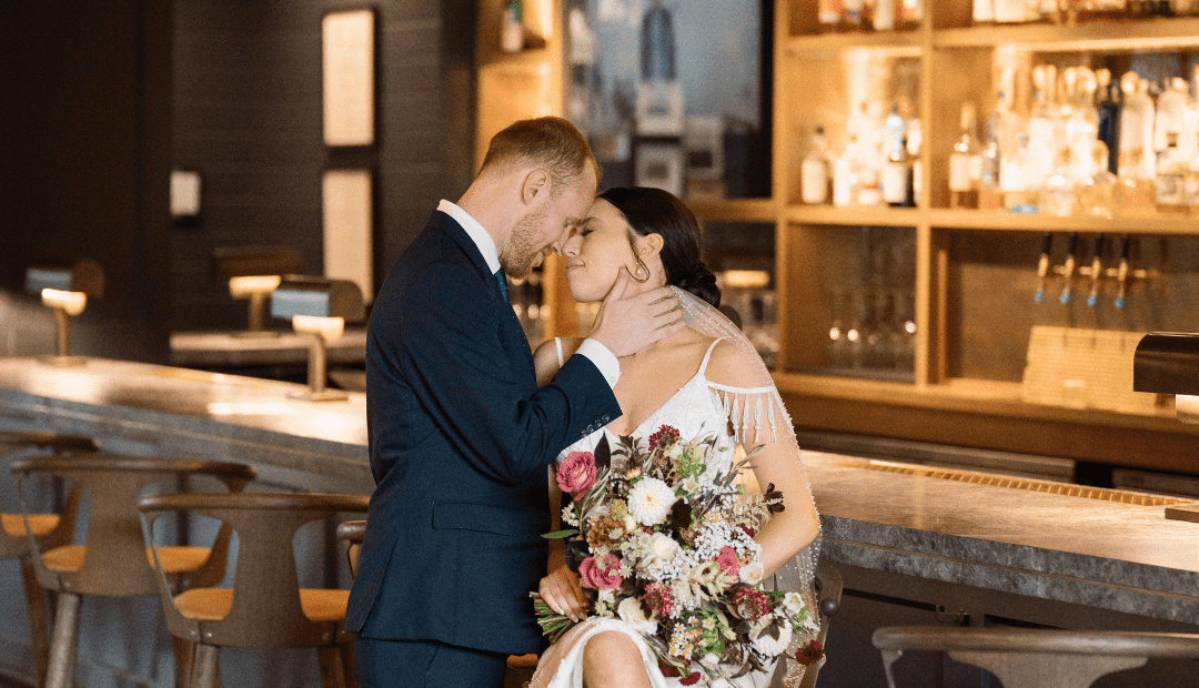 Bride and groom embracing at a bar