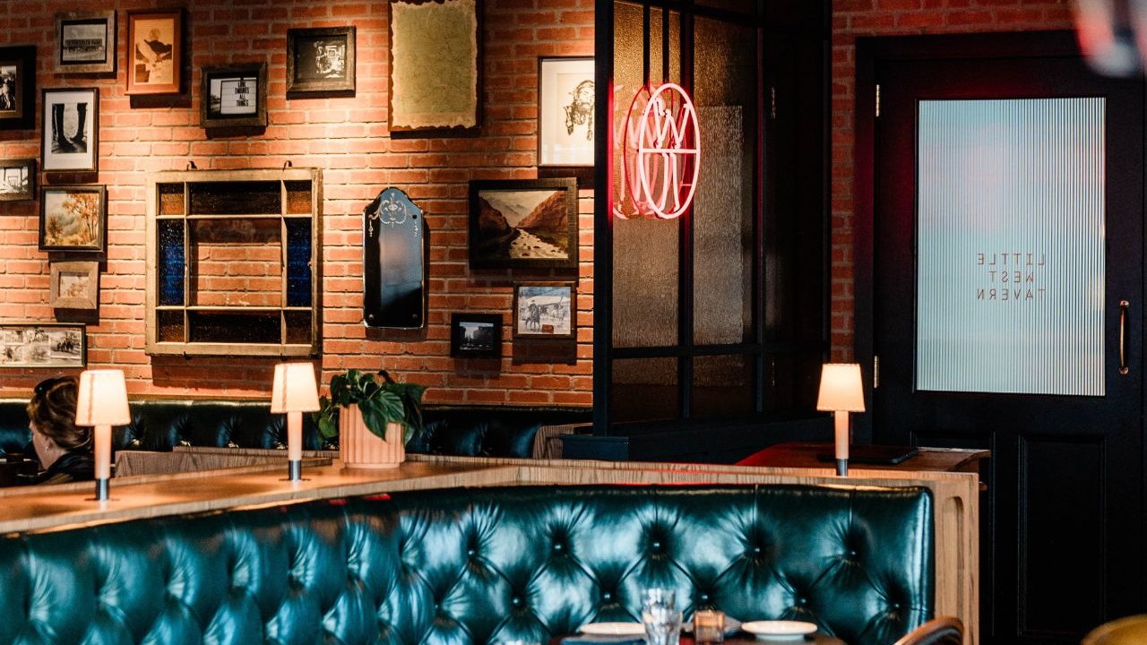 Little West Tavern dining room with leather booth and gallery wall