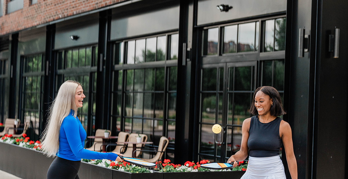 Woman with pickle ball paddles outside