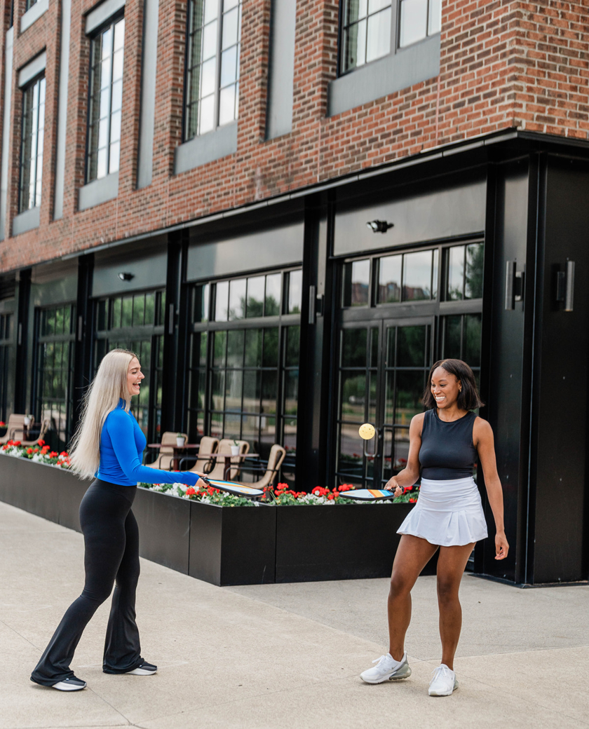 Woman with pickle ball paddles outside