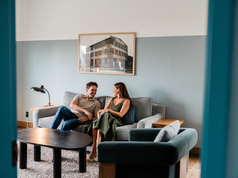 Couple sitting on couch in guest room