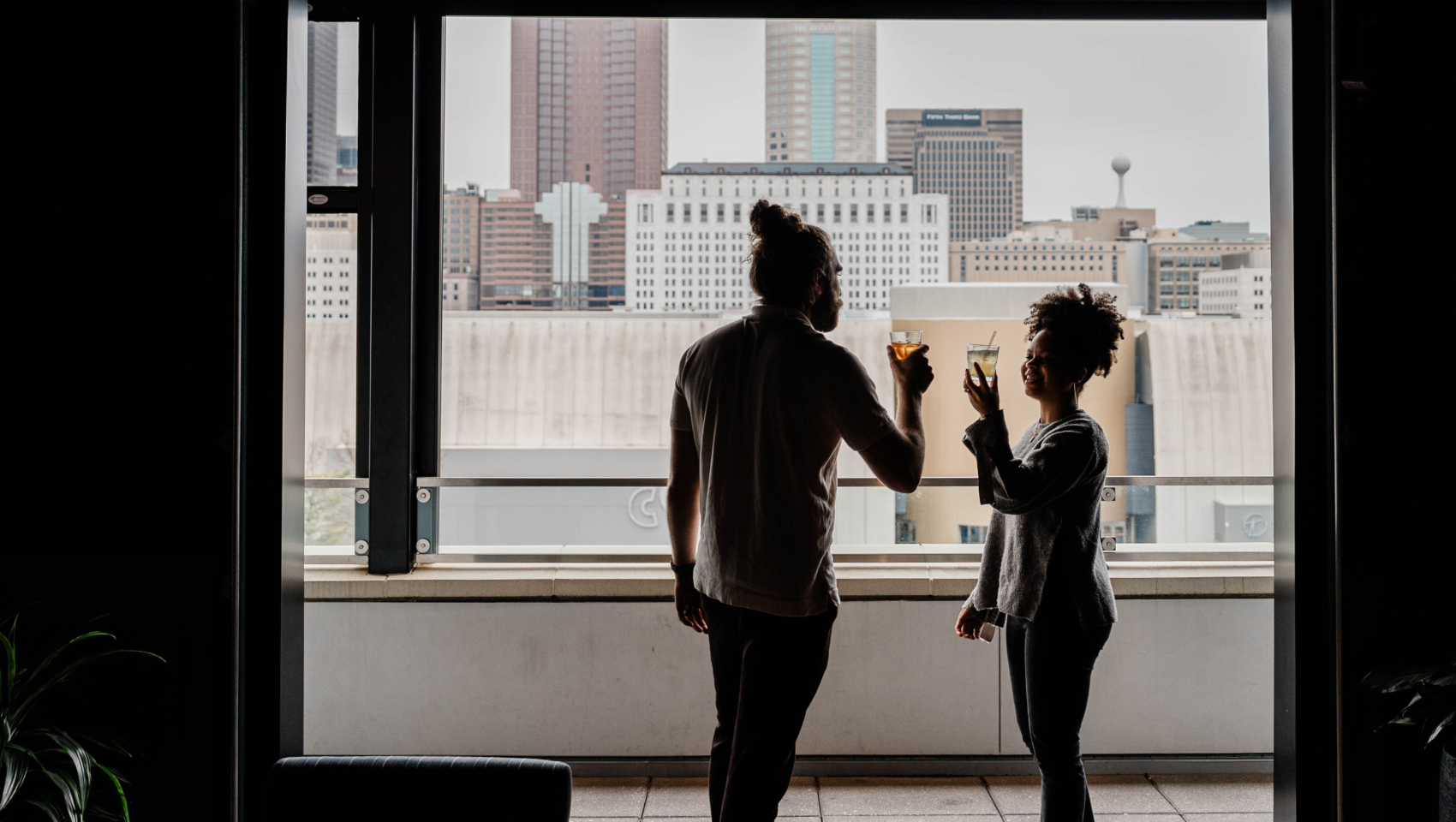 Man and woman sharing a drink on rooftop