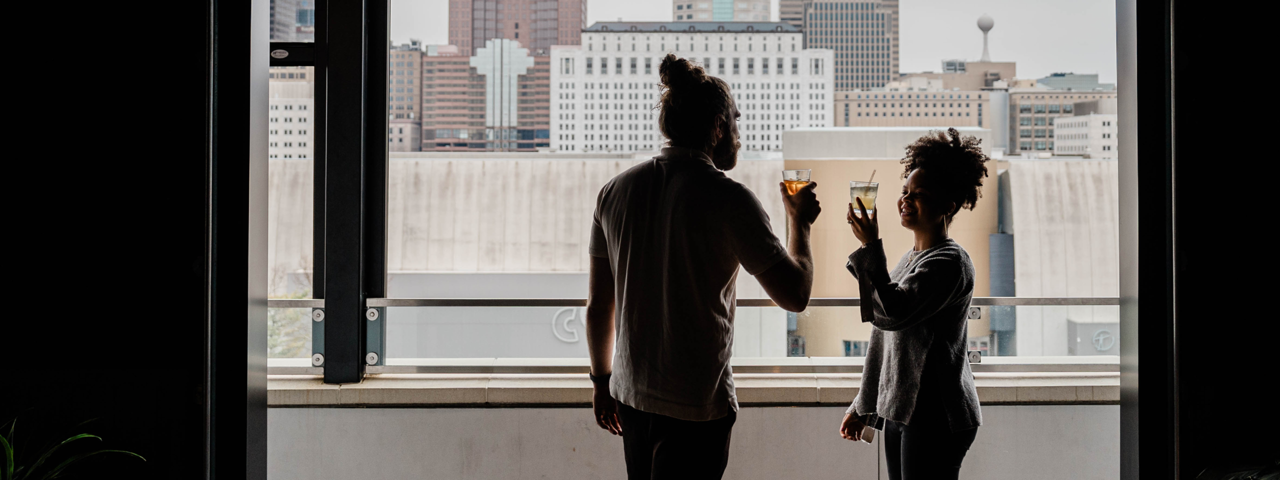 Man and woman sharing a drink on rooftop